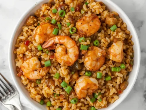 A steaming Cajun shrimp and wild rice skillet, rich with spices and ingredients.
