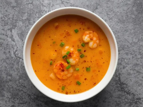 A steaming bowl of creamy shrimp bisque, perfect as a starter.