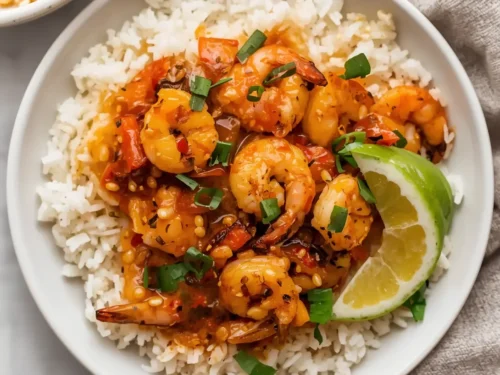 A serving of honey chili grilled shrimp with rice on a plate.
