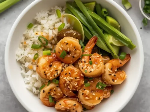 A vibrant honey garlic shrimp bowl filled with colorful vegetables and rice.