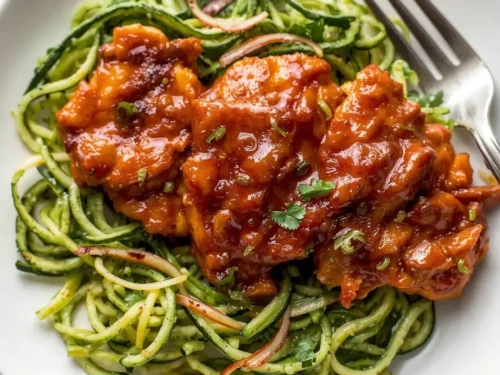 A plate of skinny BBQ chicken served with fresh zoodles.