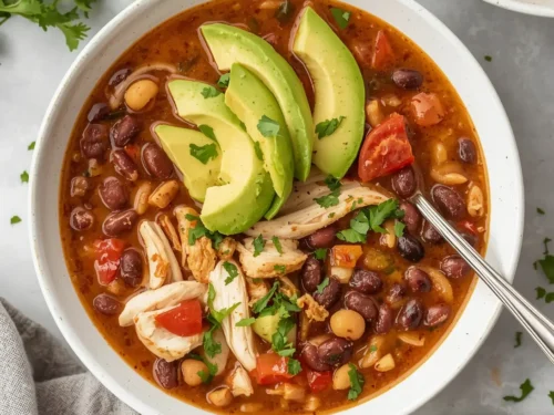 A bowl of slow cooker chicken and black bean soup garnished with cilantro