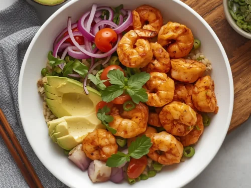 A vibrant spicy shrimp grain bowl topped with creamy avocado slices.