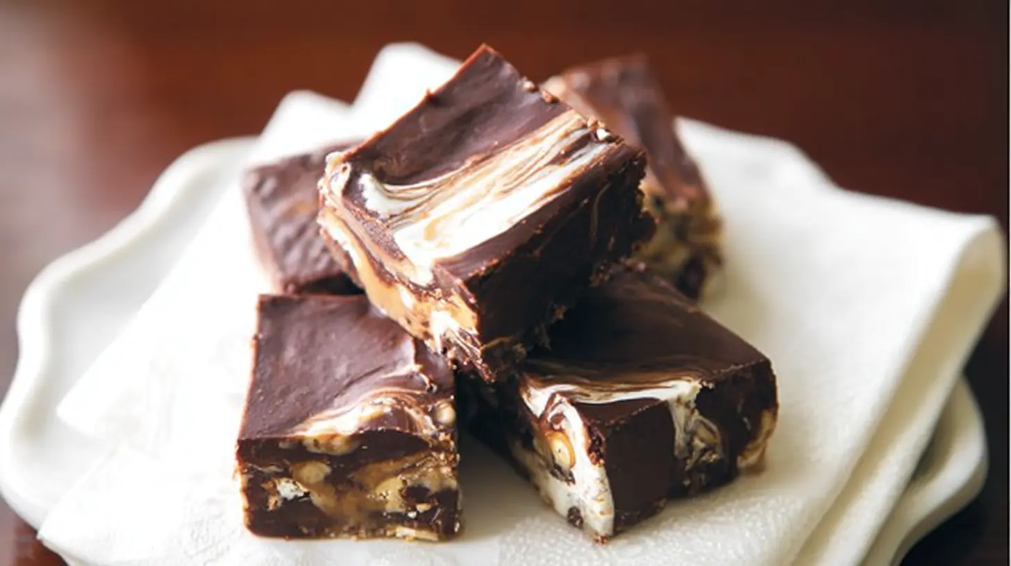 A rectangular slab of marshmallow swirl fudge with visible white marshmallow streaks