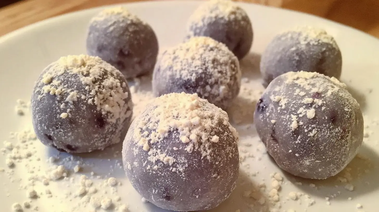 A close-up of white chocolate blueberry truffles arranged on a platter, showcasing their smooth coating.