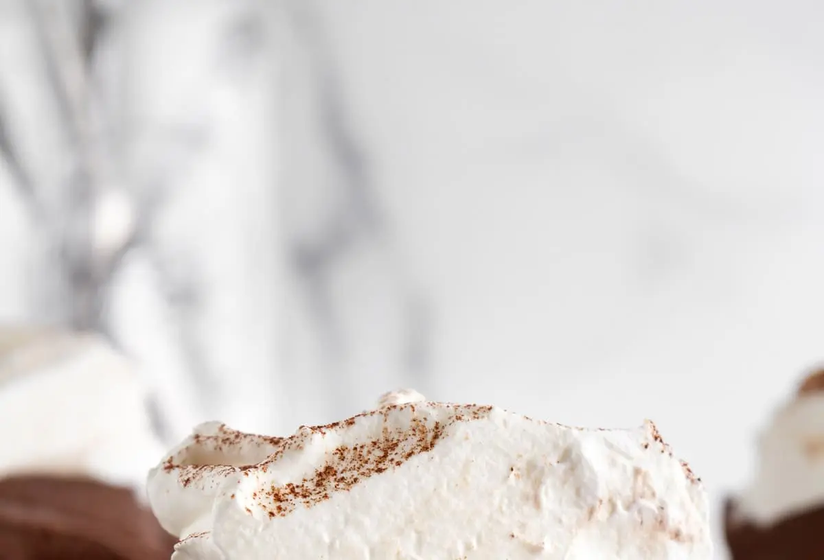 A rich Mississippi mud pie with chocolate layers, topped with whipped cream and chocolate shavings